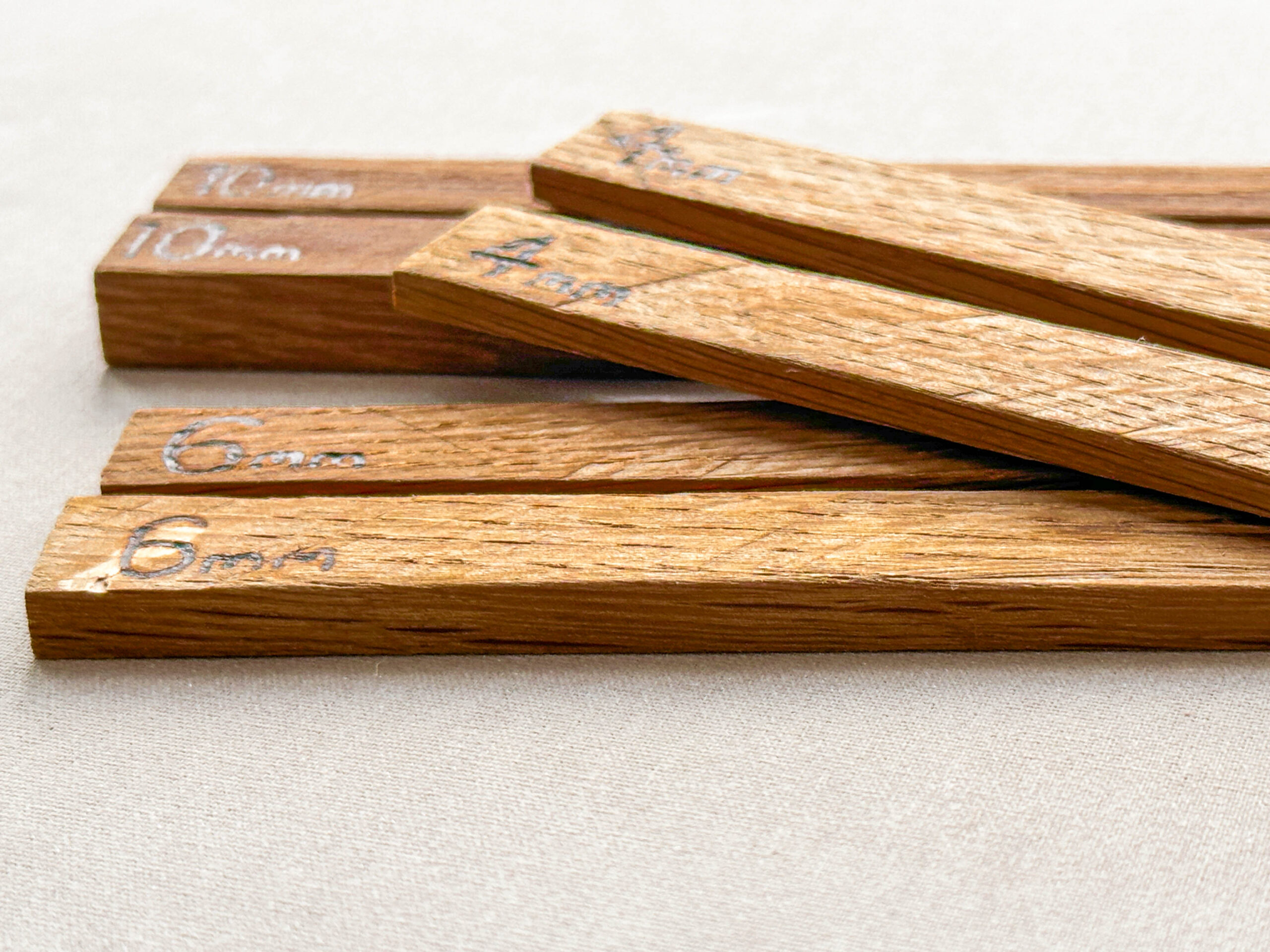 Six wooden strips of different thicknesses, branded with millimetre dimensions to help roll dough to a consistent height