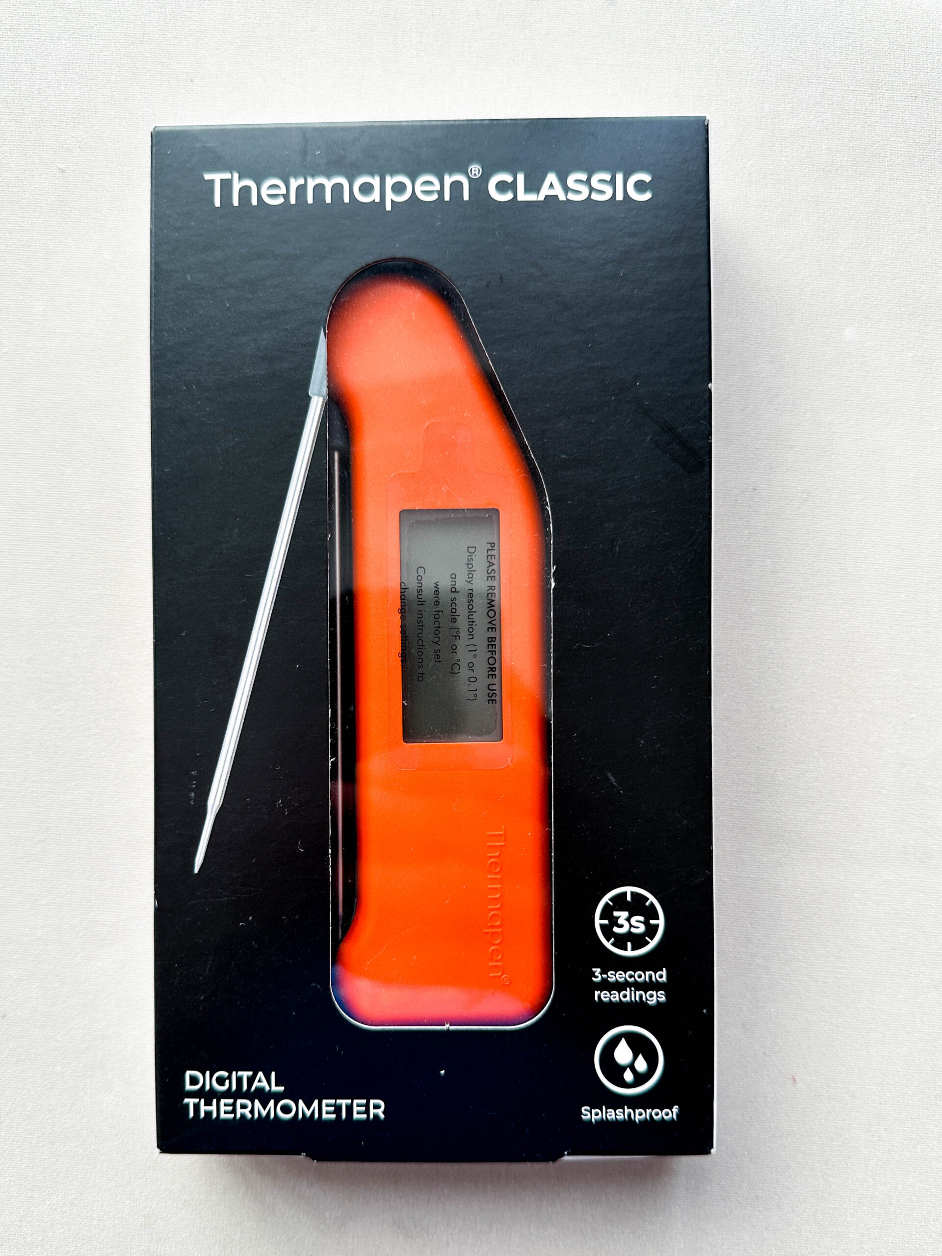 Orange plastic thermometer with foldable probe and digital display screen