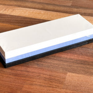 Tiered whetstone block, with white and blue layers on wooden background