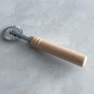 Metal dough and pastry cutter with fluted wheel with wooden handle