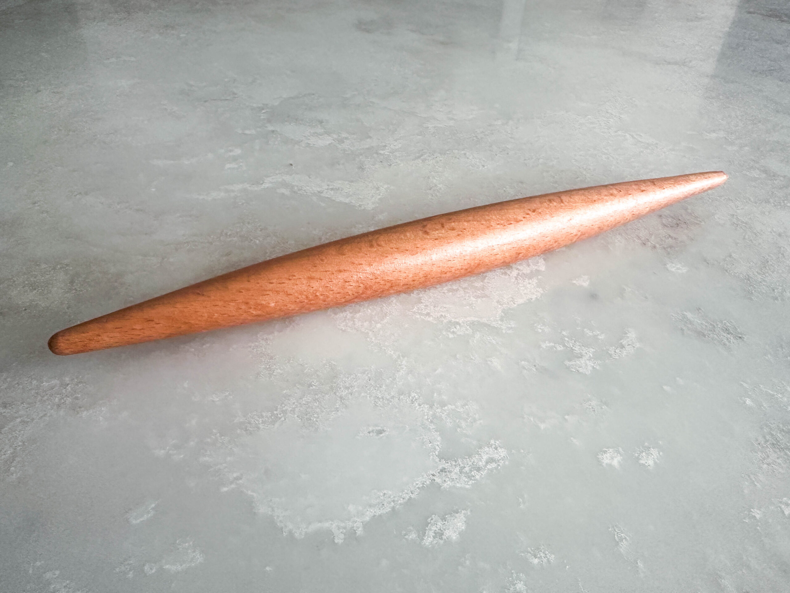 Smooth wooden rolling pin, tapered at each end
