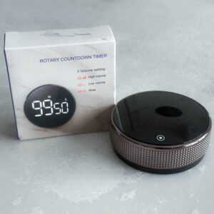 Round kitchen timer, with black and metallic details and white packaging