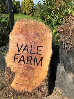 Wooden sign displaying "Vale Farm"